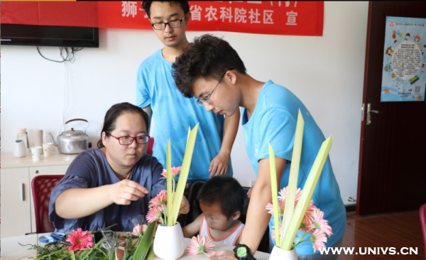 志愿者帮助母子完成插花作品(供图 岑思雨)